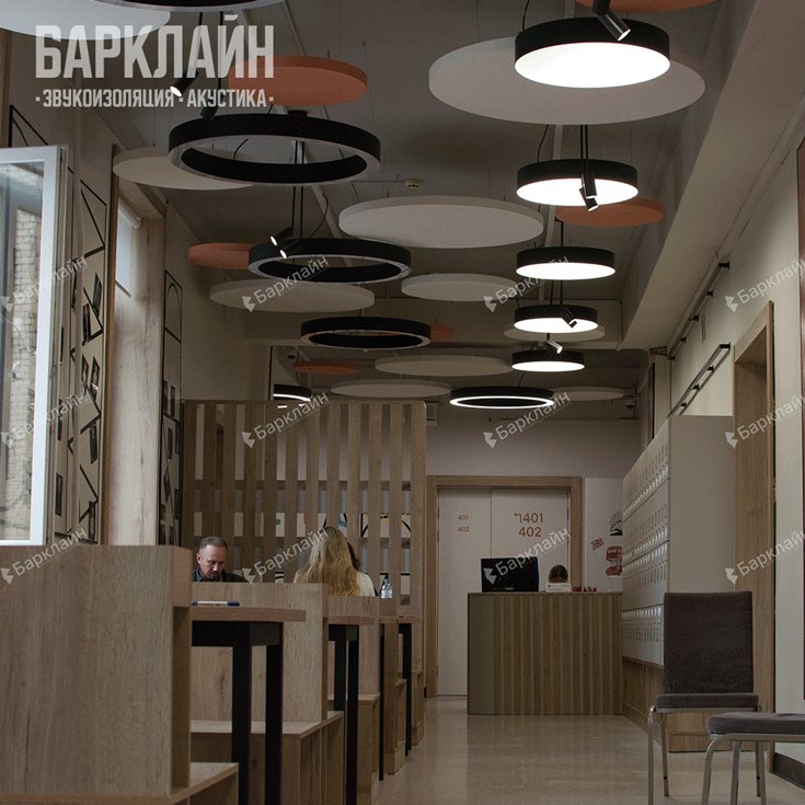 Результат монтажа акустических островов в школе — потолочный арт-объект из светлых и ярких панелей, зонирующий пространство рекреации